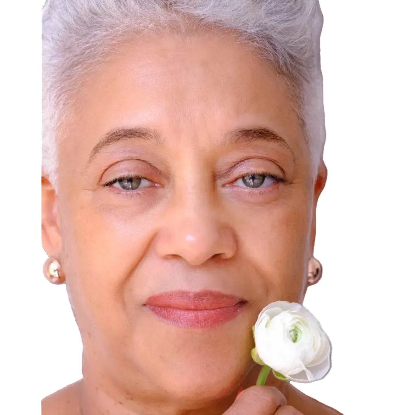 Woman holding a white flower against a plain background wearing vegan makeup colored from superfoods beets potatoes vegetables 
