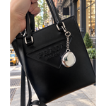 Fluency Color Me Ready silver chrome compact keychain attached to a black Prada bag on a New York City sidewalk